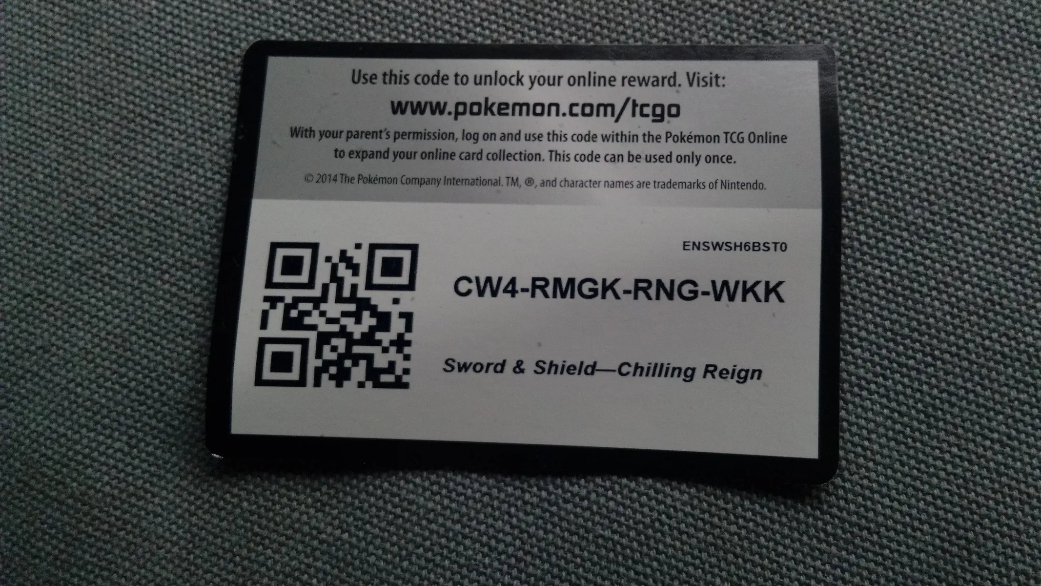 Een codekaart voor het Pokémon Trading Card Game met een QR-code en een unieke alphanumeric code.