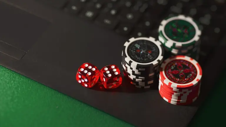 Casinofiches en rode dobbelstenen op een laptoptoetsenbord
