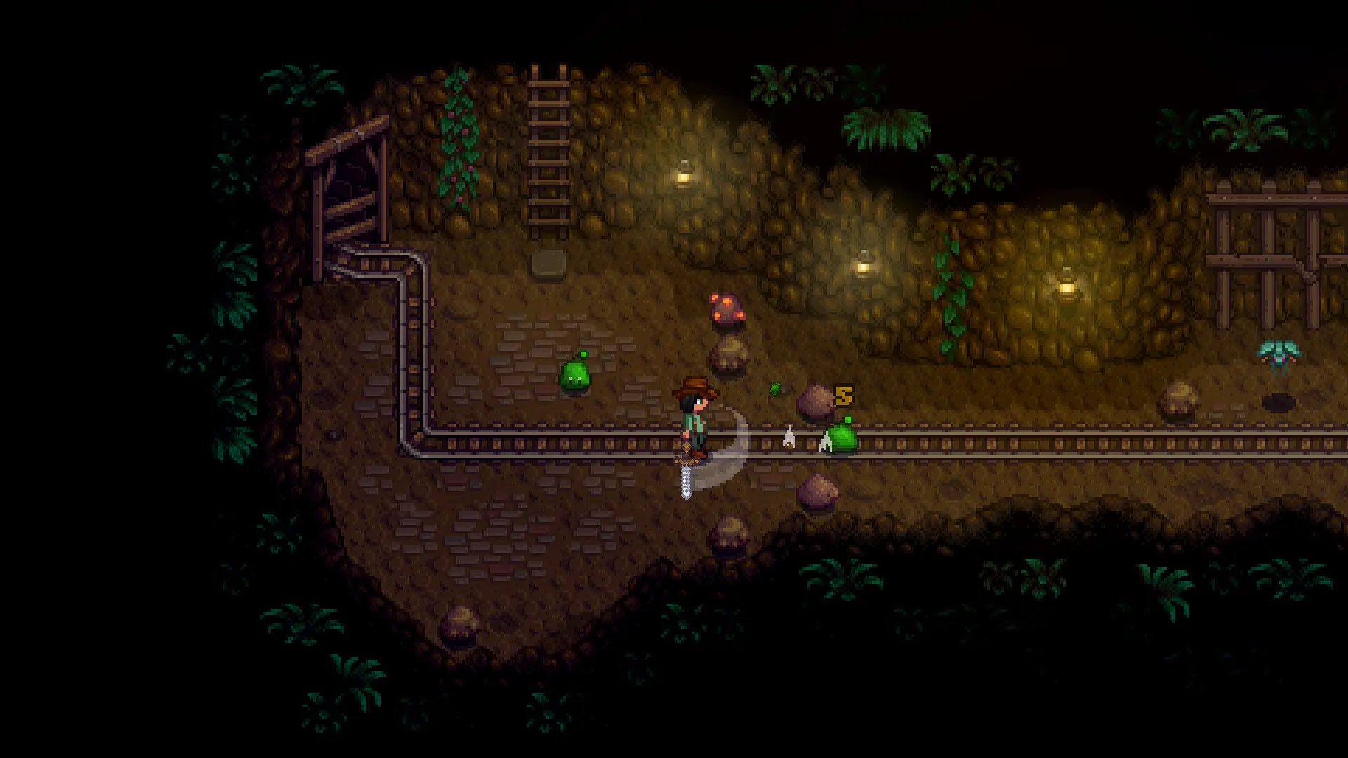 Een personage uit Stardew Valley die met een zwaard in een donkere mijn staat naast een railsysteem.